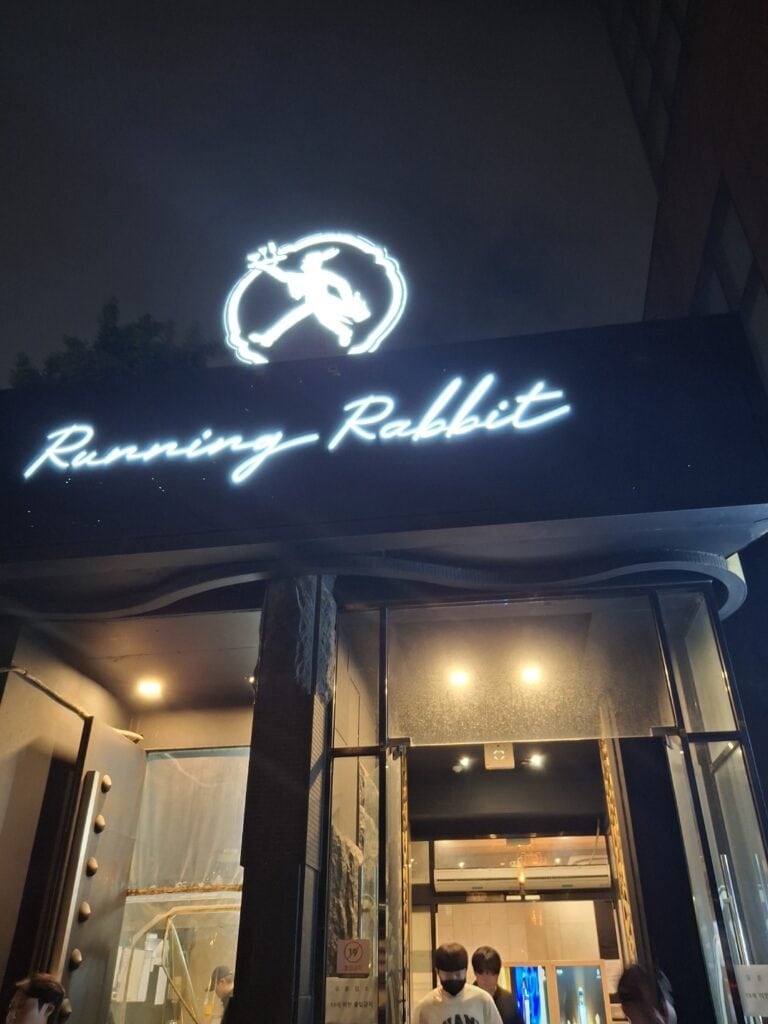 강남 달토 런닝레빗 유흥 업소의 입구 야경 간판 사진, 런닝 토끼 로고가 조명을 밝히고 있음