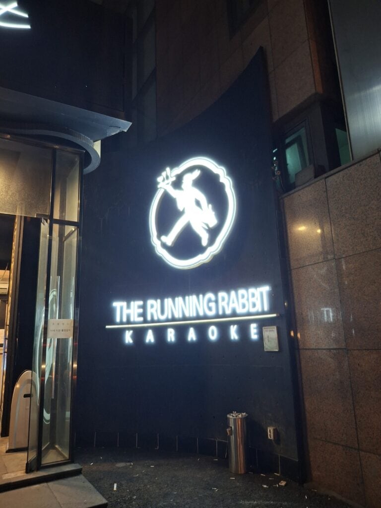 강남 유흥업소 런닝레빗 달토의 외부 간판, THE RUNNING RABBIT KARAOKE 로고가 네온으로 표시된 야간 전경